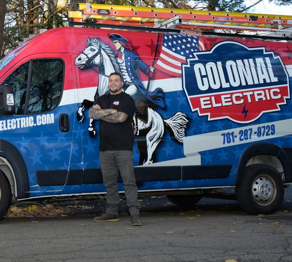 Founder Scott Hays standing in front of the red, white and blue Colonial Electric van