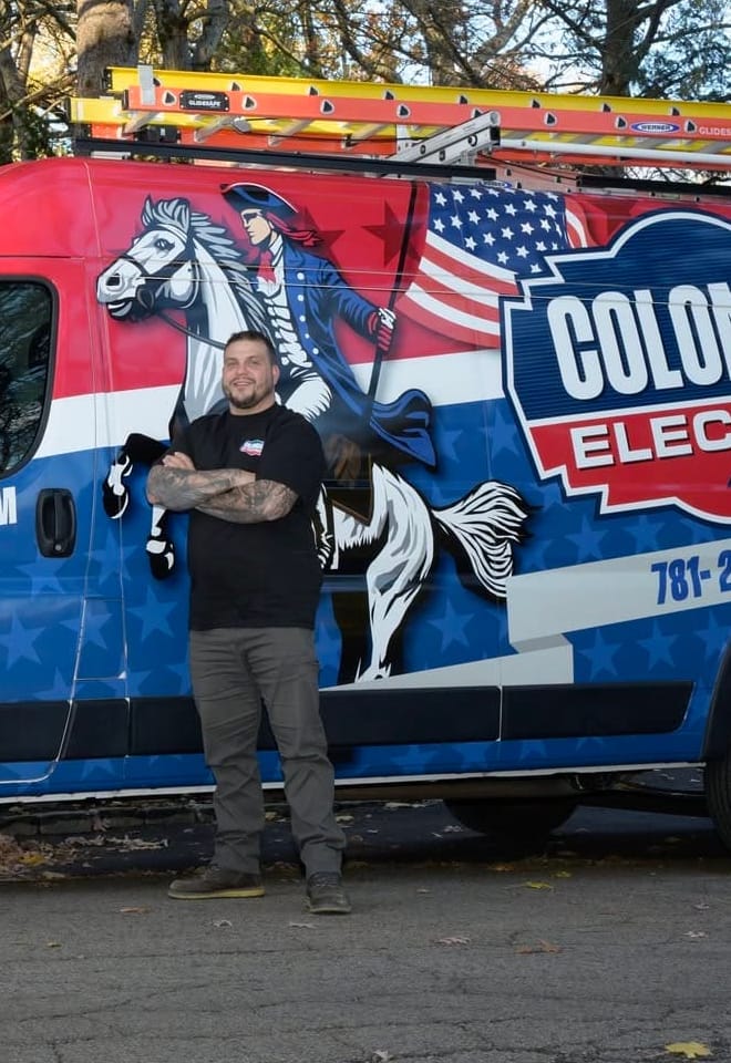 Founder Scott Hays standing in front of the Colonial Electric van