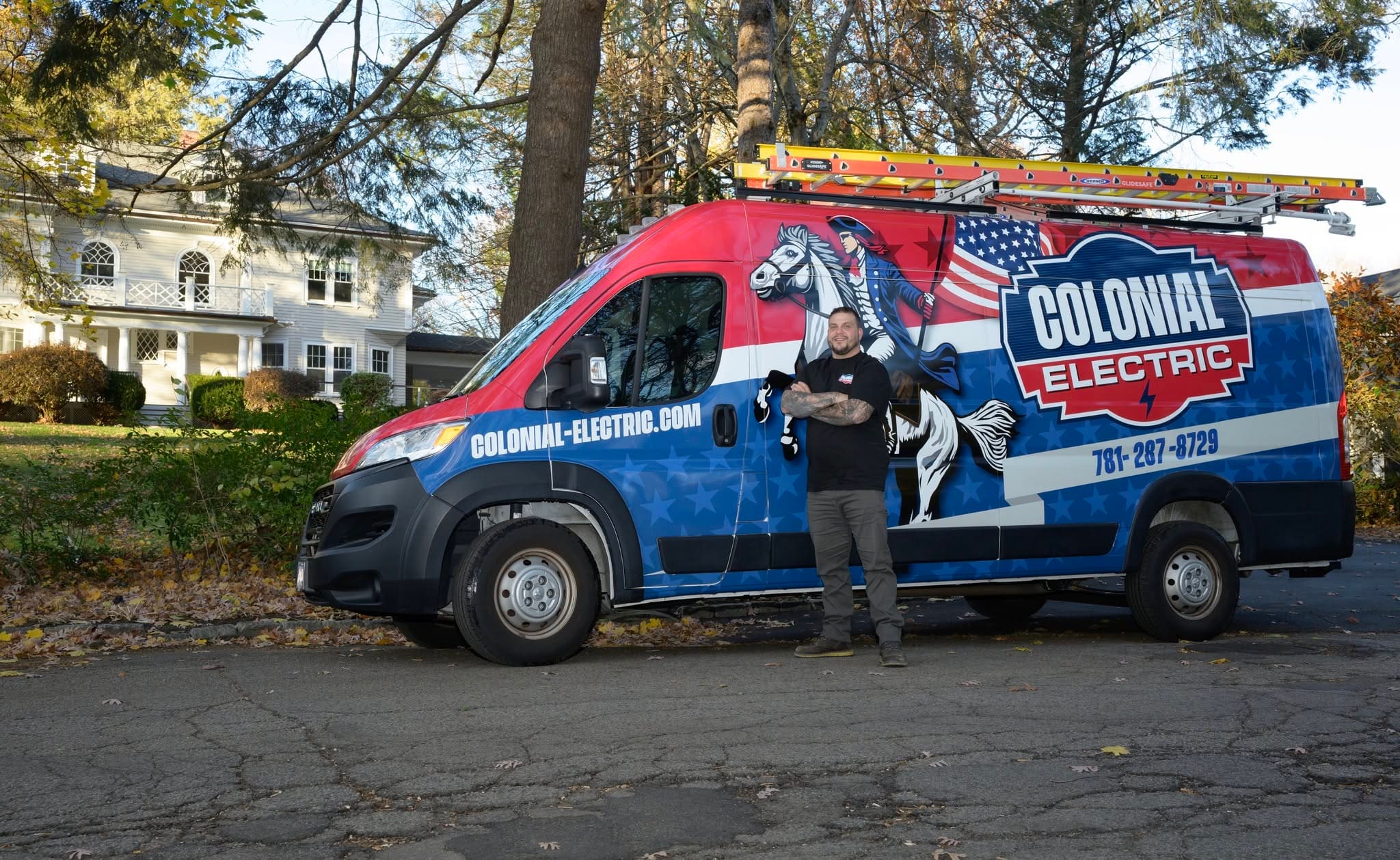 Founder Scott Hays standing in front of the red, white and blue Colonial Electric van