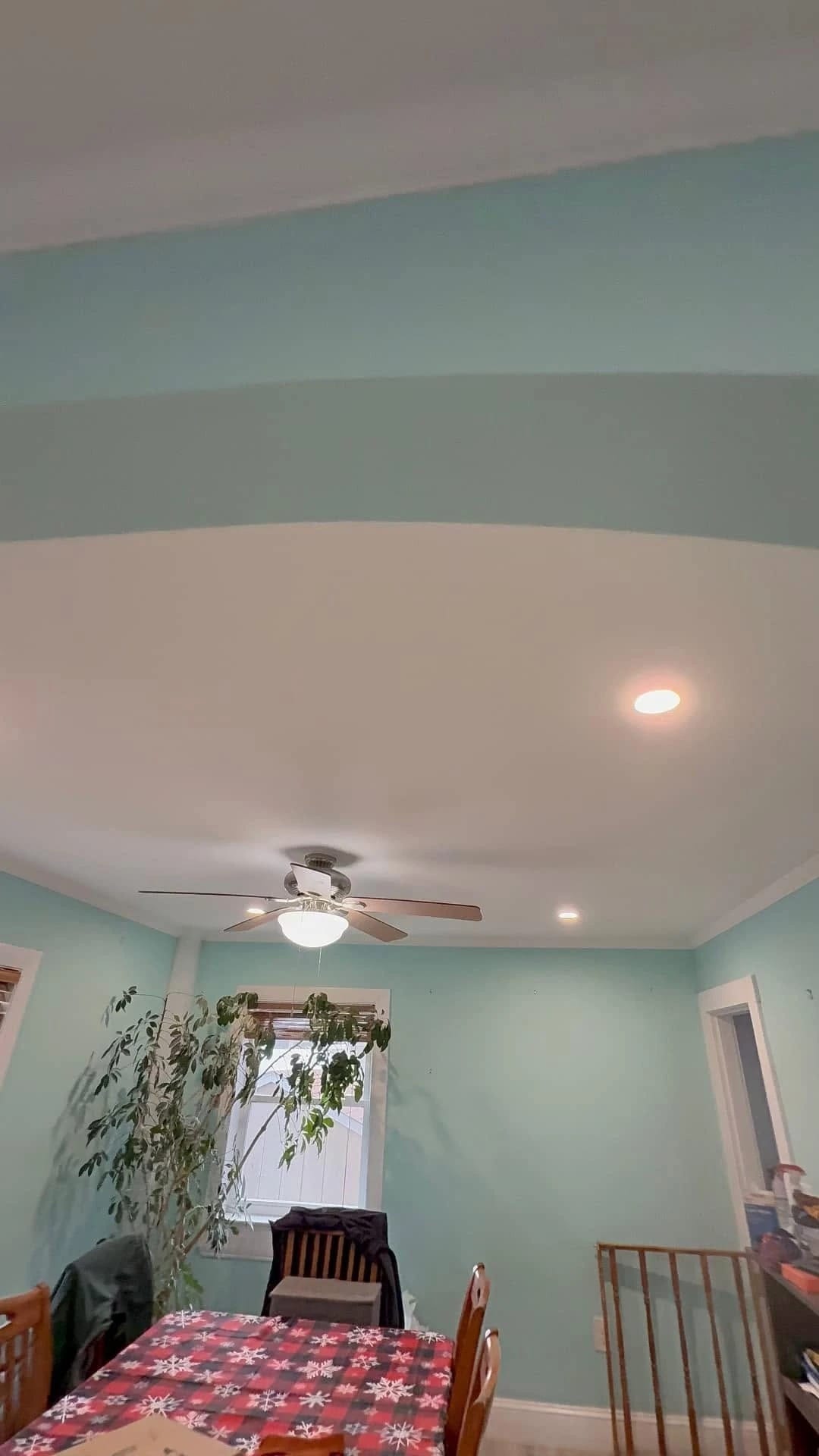 Ceiling fan with a light kit and recessed lights over a dining room