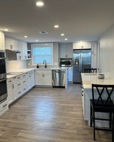 Recessed ceiling lights evenly spaced across a remodeled kitchen, a Colonial Electric job
