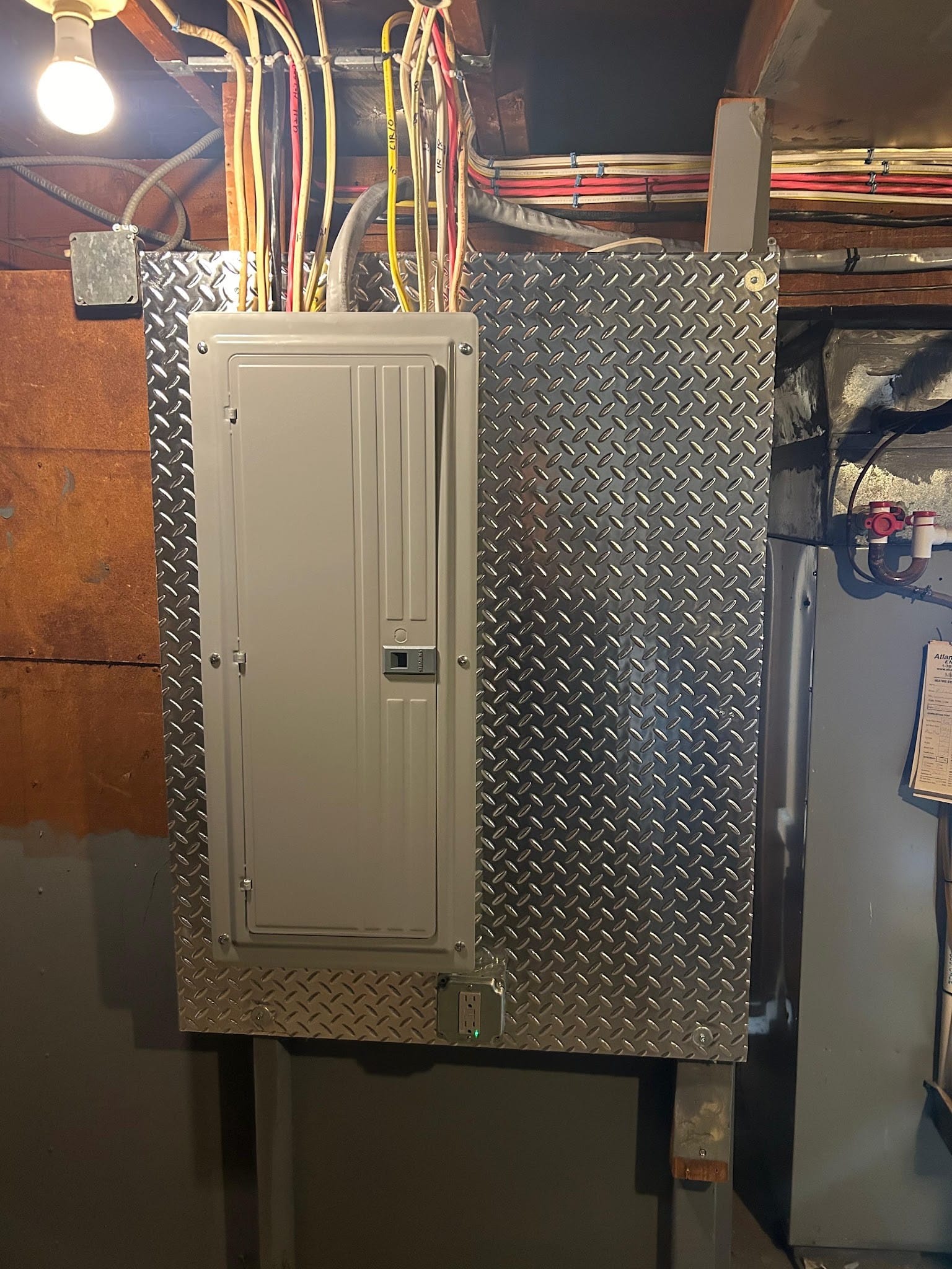 New cable runs dropped into a breaker panel on a diamond-plate backboard